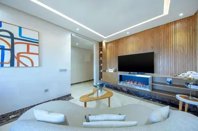 a living room with a large tv and a couch at Luxury Suite Mannesmann - Seaview in Mohammedia