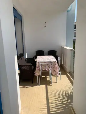a table and chairs in a room with a table and a table and chairs at Résidence Perla Andalusia Vue Sur Mer in Mansouria