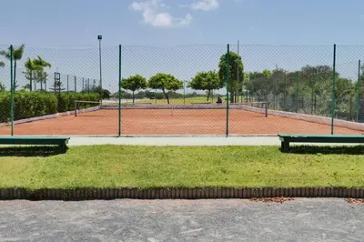 a tennis court with three benches on a tennis court at Appartement Haut Standing - Bouznika plage in Bouznika