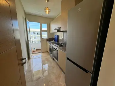 a kitchen with a refrigerator and a stove at Sublime appart piscines & espaces jeux, proche mer in Bouznika