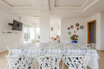 a white dining room with a white table and chairs at Beachfront Escape - Panoramic View and Spacious Terrace in Skhirat