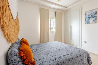 a bedroom with a bed with orange pillows on it at Beachfront Escape - Panoramic View and Spacious Terrace in Skhirat