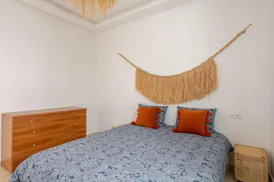a bedroom with a blue bed with orange pillows at Beachfront Escape - Panoramic View and Spacious Terrace in Skhirat
