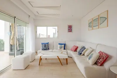 a living room with a white couch and a table at Beachfront Escape - Panoramic View and Spacious Terrace in Skhirat