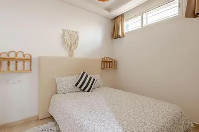 a bedroom with a bed and two windows at Beachfront Escape - Panoramic View and Spacious Terrace in Skhirat