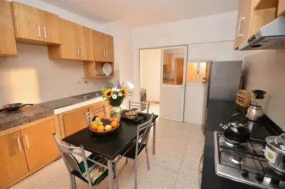 a kitchen with a table with a bowl of fruit on it at Spacious Haven in Abdelmoumen in Casablanca