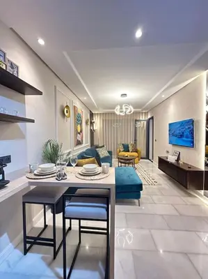 a living room with a table and a couch at Stylish Appartement Lumineux et Luxueux Au Coeur De Maarif Quartier Palmier Près De Station Tramway & Bd Abdelmoumen Casablanca in Casablanca
