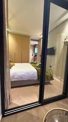 a mirror in a room with a bed in a bedroom at Stylish Appartement Lumineux et Luxueux Au Coeur De Maarif Quartier Palmier Près De Station Tramway & Bd Abdelmoumen Casablanca in Casablanca