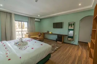 a hotel room with a bed and a television at Hôtel Hariz Son in Berrechid
