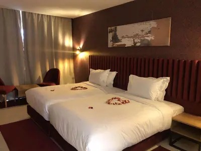 a hotel room with a large bed with flowers on it at Hôtel Hariz Son in Berrechid