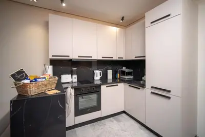 a kitchen with white cabinets and a black counter top at Luxury Studio in Luxury Place in Casablanca