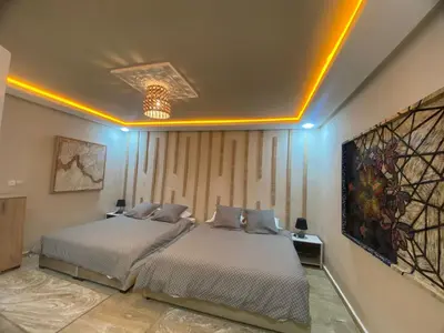 two beds in a room with blue lights at Un écrin rabati in Rabat
