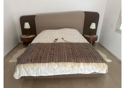 a bed in a room with two lamps on two tables at Villa luxe avec piscine in Oulad Hamida