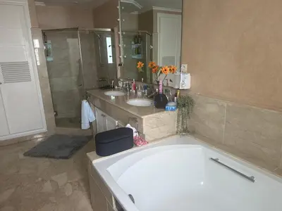 a bathroom with a tub and two sinks and a shower at Villa luxe avec piscine in Oulad Hamida