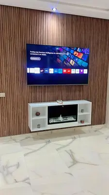 a flat screen tv on a wooden wall with a entertainment center at Bel appartement à louer sur bouznika de 117 m2 in Bouznika