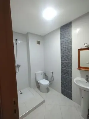 a white bathroom with a toilet and a sink at Appartement très propre lumineux en moyen standing a résidence klk darbouza in Casablanca