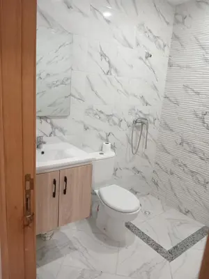 a white bathroom with a toilet and a sink at L'ocean in Casablanca