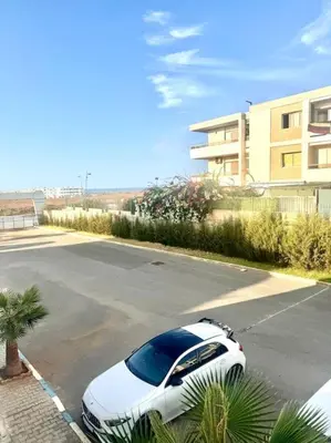 a white car parked in a parking lot at Bel Appartement vue piscine in Mansouria