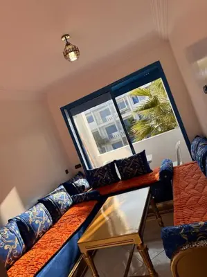 a living room with a blue couch and a window at Bel Appartement vue piscine in Mansouria