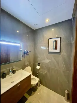 a bathroom with a white toilet and a sink at Vue imprenable sur Casa Finance City in Casablanca