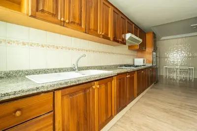 a large kitchen with wooden cabinets and a sink at Appartement à Maarif, Proche du Twin et McDonald's in Casablanca
