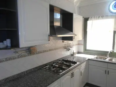 a kitchen with white cabinets and a stove top oven at Spacious apartment in Rabat Agdal 1937,5 ft2 - 180m2 in Rabat