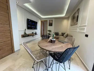 a dining room table and chairs in a living room at Golden Spot Casablanca in Casablanca