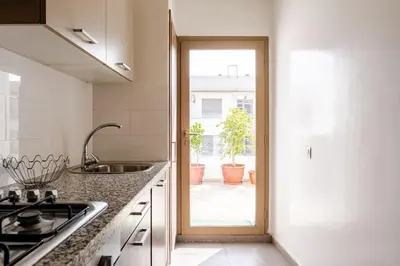 a kitchen with a sink and a door to a patio at Loft Moderne Cosy avec Terrasse vue unique centre de Casablanca in Casablanca