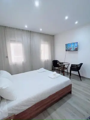 a bedroom with a bed and a table and chairs at Studio l'Escale D'Agdal in Rabat