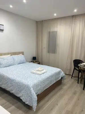 a bedroom with a bed with a blue comforter at Studio l'Escale D'Agdal in Rabat