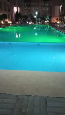 a large swimming pool with green illumination at night at Apartment in O Ben Slimane