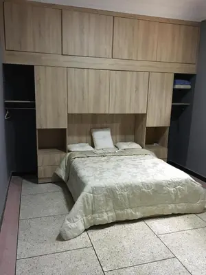 a bedroom with a large bed with a wooden headboard at larc in Deroua