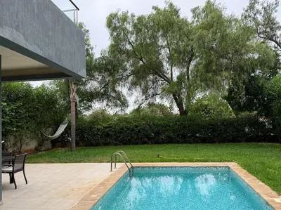 a swimming pool in front of a house at Luxurious Golf Villa with Pool in Bouskoura