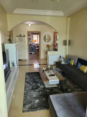a living room with a couch and a table at Ricoflores palm benslimane in O Ben Slimane