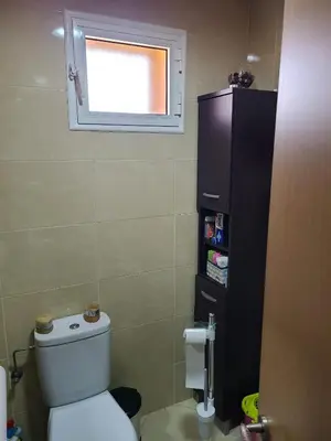 a small bathroom with a toilet and a window at Ricoflores palm benslimane in O Ben Slimane