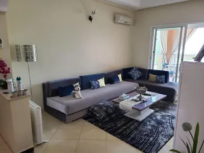 a living room with a couch and a table at Ricoflores palm benslimane in O Ben Slimane