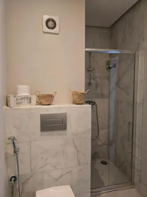 a bathroom with a glass shower and a toilet at Charmant appartement à 10min de L' Aéroport Med V in Nouaceur