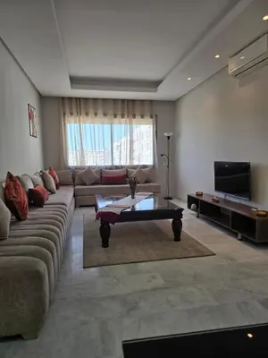 a living room with a couch and a coffee table at Charmant appartement à 10min de L' Aéroport Med V in Nouaceur