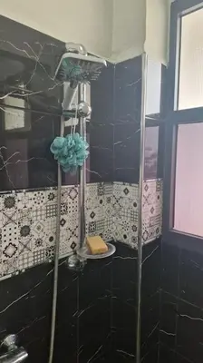 a shower in a bathroom with a black wall at Welcome to km 0 of Casablanca in Casablanca