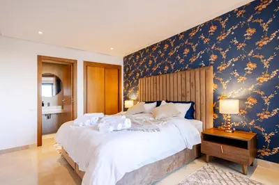 a bedroom with a large bed with a blue wall at Emplacement Chic Lumineux & Central Près du Consulat Américain 2 minutes de Twin Center Gauthier Casablanca in Casablanca