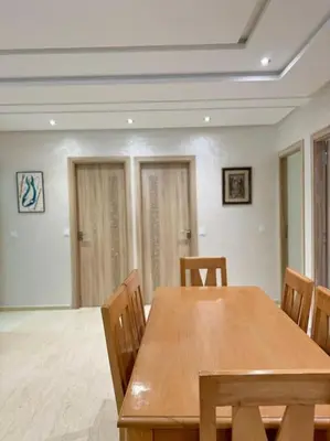 a dining room with a wooden table and chairs at Nice appartement In Rabat-Temara in Temara