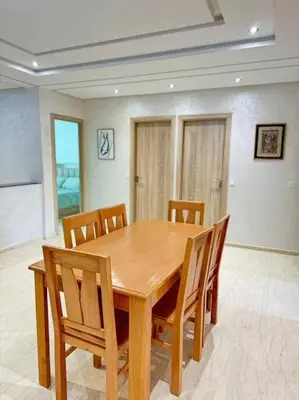 a wooden table and chairs in a room at Nice appartement In Rabat-Temara in Temara