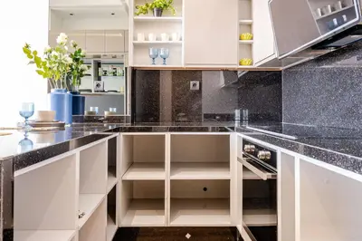 a kitchen with white cabinets and black marble counter tops at Modern Ocean View Apartment in Casablanca