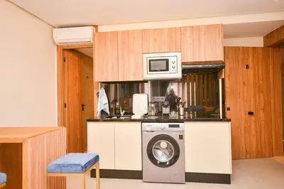 a kitchen with a washing machine and a microwave at Studio 08 Maarif - High Speed Wi-Fi in Casablanca