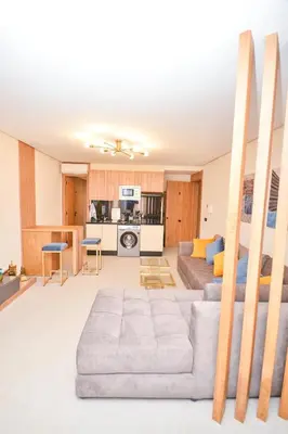 a living room with a couch and a kitchen at Studio 08 Maarif - High Speed Wi-Fi in Casablanca