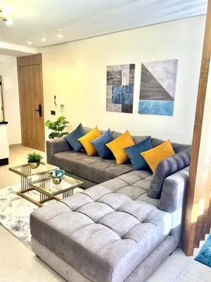 a living room with a gray couch and yellow pillows at Studio 08 Maarif - High Speed Wi-Fi in Casablanca