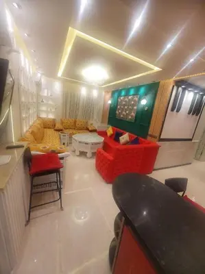 a living room with a red chair and a couch at Grand et magnifique appartement in Casablanca