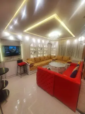 a living room with a red couch and a tv at Grand et magnifique appartement in Casablanca