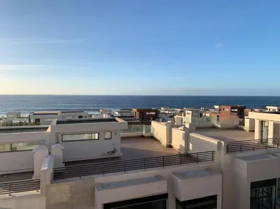 a view of the ocean from the balcony of a building at The Atlantica Ocean view apartment in Dar Bouazza