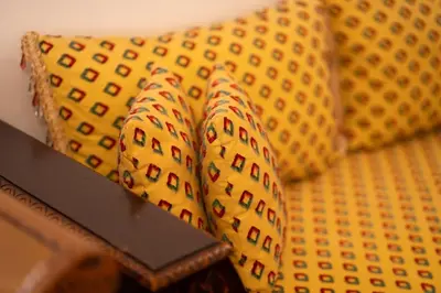a yellow couch with two pillows on it at Appartement Cosy et Confortable in Casablanca